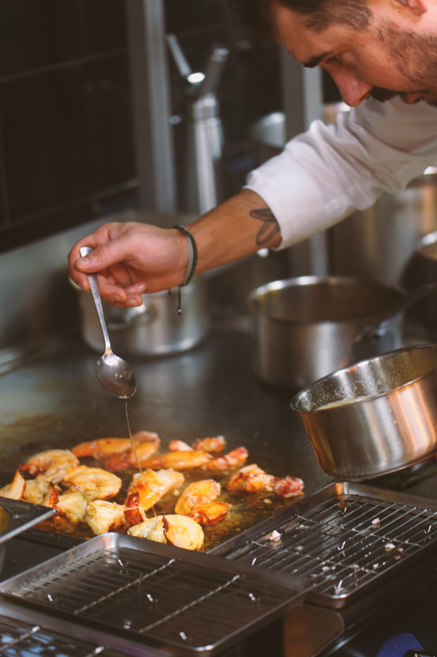 Le chef saisit des langoustines à la plancha